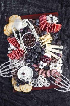 a platter filled with meats, cheeses, fruit and other food items