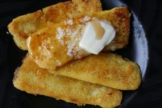 some fried food on a black plate with butter and sauce in the middle, ready to be eaten