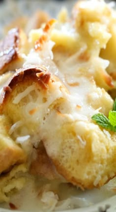 a close up of a plate of food with bread and cheese on it, covered in gravy