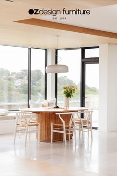 a dining room table and chairs in front of large windows