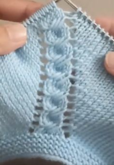 someone is crocheting the stitches on a blue knitted sweater