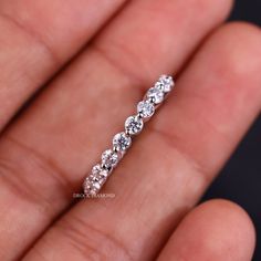 a close up of a person's hand holding a diamond ring