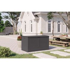 an outdoor storage box sitting in front of a house with picnic tables and benches around it