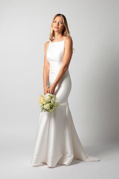 a woman in a white dress holding a bouquet