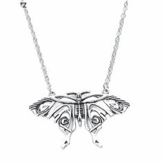 a silver necklace with a butterfly on it's back and two eyes in the center