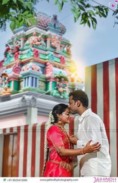 a man and woman standing next to each other in front of a building with colorful decorations