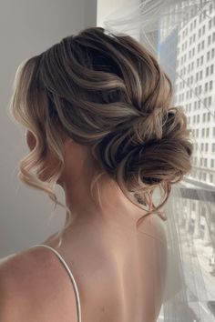 the back of a woman's head, wearing a wedding hairdo and veil