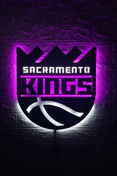 sacramento kings neon sign mounted to the side of a brick wall