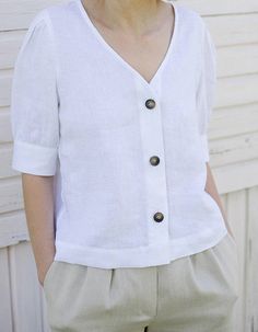 "Classic white and black women V-neck button down blouse, easy to be layered with camisole as a shirt or by itself as a blouse. The puffy sleeves are very flattering; pair it with pants, jeans or skirts for a chic and young look. - Prewashed medium weight linen (180g) - Relaxed fit - Button down opening - Elbow-length puffed sleeves with cuff and button - Can be tucked or untucked Please provide your shoulder width, full bust measurement ( measured around the fullest part) and your height in the Relaxed Fit V-neck Blouse With Buttons, Summer V-neck Blouse With Button Cuffs, Spring V-neck Blouse With Button Cuffs, V-neck Top With Button Cuffs For Day Out, Casual White V-neck Top For Work, Classic Solid Color V-neck Blouse, Classic V-neck Solid Color Blouse, Summer V-neck Tops With Button Cuffs, Half Sleeve Blouse For Day Out