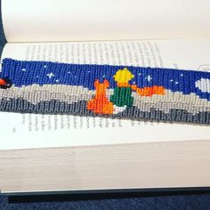 an open book with a beaded bracelet on it