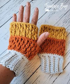 someone is holding up their hand made crocheted gloves