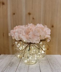 three mason jars with pink flowers in them