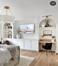 a bedroom with white walls and wood flooring has a bed, desk, chair, bookshelf and artwork on the wall