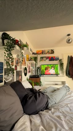 a bed with lots of pillows and pictures on the wall next to it in a bedroom