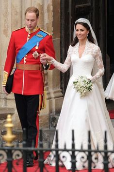 the bride and groom are walking down the red carpet