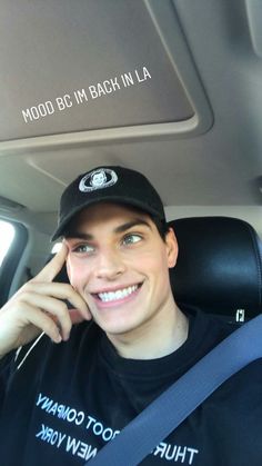 a man sitting in the back seat of a car talking on a cell phone