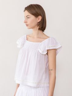 This is a feminine and unique top by JMARK New York that is made out of high quality and sturdy fabric. With trendy design detail and refined romantic mood, you can style it for your daily casual outfit.- Elastic band on the shoulder- Pin tuck detail on the front- Set up with matching skirt Summer Relaxed Fit Flutter Sleeve Tops, Cotton Flutter Sleeve Top For Brunch, Relaxed Fit Flutter Sleeve Tops For Day Out, Flutter Sleeve Tops For Day Out, Feminine Flutter Sleeve Tops For Day Out, Chic Cotton Top For Brunch, Chic Summer Tops With Flutter Sleeves, Elegant Spring Blouse With Elastic Shoulders, Chic Cotton Ruffle Tops