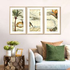 three framed maps hang on the wall above a couch in a room with a table and chair