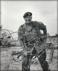 a man in uniform standing behind barbed wire