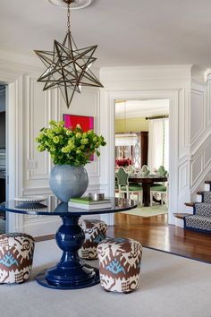 a vase with flowers sitting on top of a table in a living room next to stairs