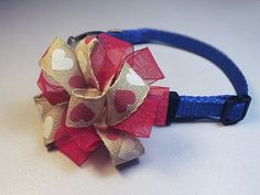 a red, white and blue bow on a dog's headband with polka dots