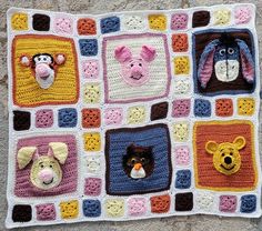 a crocheted blanket with animals on it and squares in the middle that have been made to look like they are smiling