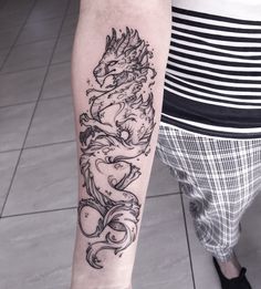 a woman's arm with a dragon tattoo on the left side of her body