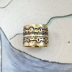 Upgrade your bandana with this versatile and fun classic ring. Add a touch of Southwest aesthetic flair to your look and ramp up your style game! To wear, wrap your bandana as desired, then push both ends of the bandana through the ring on the back of the slide and pull ends through to adjust. Cast out of brass Approximately 1" d Polishing regularly with an inexpensive polishing cloth, or you can allow the brass to patina naturally Southwest Aesthetic, Bandana Slide, Small Drawstring Bag, Texas Gifts, Men Fashion Casual Outfits, Poly Bags, Brass Jewelry, Classic Ring, Gift Accessories