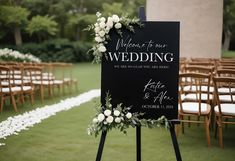 a sign with flowers on it sitting in front of rows of chairs at a wedding