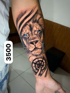 a man's arm with a lion and compass tattoo on the left side of his arm