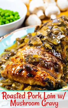 roasted pork loin w / mushroom gravy on a plate with green peas