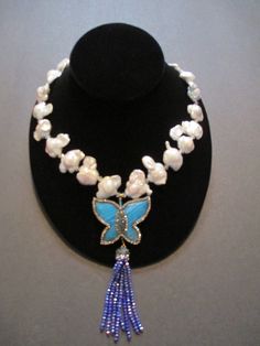 "This fresh water keshi pearl necklace consists of 24 high luster free form pearls with Swarovski crystals between them. They are slightly graduated with the larger ones towards the center of the necklace . There is a lovely ocean blue colored agate butterfly pendent trimmed in small crystals with a dark blue beaded tassel. The necklace measures 24\" in length with a silver colored lobster claw clasp. This necklace will look stunning with  any outfit.  That is the beauty of this piece. Pearls never go out of style." Luxury Blue Pearl Necklace With Charm, Keshi Pearl Necklace, Small Crystals, Keshi Pearls, Blue Agate, Ocean Blue, Beaded Pendant, Chain Styles, Gemstone Necklace