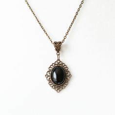 This romantic necklace is made from antique bronze chain and a black agate cabochon housed in an ornate filigree setting. This necklace is also available in antique silver finish. -the chain is 18 inches length -the pendant is approximately 1.25 inches long and 1 inch wide including the setting -lobster claw closure SHIPPING: Default shipping is by regular mail, which does not have tracking, shipping times are as follows: US: 1-3 weeks Canada: 1-2 weeks Europe: 2-4 weeks If you would like to add Vintage Black Oval Pendant Jewelry, Black Pendant Necklace With Vintage Charm, Elegant Black Jewelry With Antique Finish, Black Vintage Necklace With Charm, Vintage Black Cabochon Necklace, Elegant Black Filigree Necklaces, Formal Black Locket Necklace, Elegant Antique Finish Necklaces For Gifts, Elegant Oval Pendant Jewelry With Antique Finish