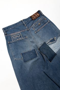 a pair of blue jeans with patches on the back and side pockets that have been cut off