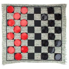 a black and white checkerboard with red buttons on it's side, made out of yarn