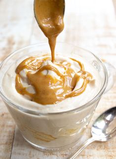 caramel sauce being drizzled over the top of a dessert in a glass bowl