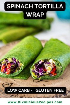 spinach tortilla wrap is cut in half and sitting on a wooden plate