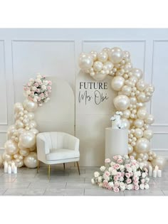 the balloon arch is decorated with flowers and white balloons