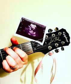 a person holding an acoustic guitar with a photo on the top and bottom of it