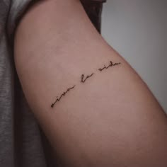 a woman's arm with the word love written in cursive writing on it