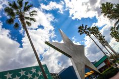 there is a large star on the side of this building in front of palm trees