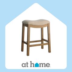 a wooden stool with a beige seat cover on it and the words at home above it