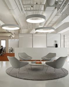 an office with chairs, tables and lamps in the middle of the room is white