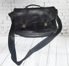 This vintage Coach Messenger Bag Briefcase Laptop is a classic addition to any collection. Made of buttery soft leather, this large bag features a solid pattern with a black color and brass hardware. The bag has a turn lock closure and a detachable strap with an adjustable strap drop.  The bag is perfect for travel, casual outings, and business meetings. It has inner pockets for easy organization and is suitable for unisex adults. The bag measures 16 inches in width, 12 inches in height, and 4 i Coach Messenger Bag, Vintage Coach, Large Bag, Timeless Pieces, Soft Leather, Adjustable Straps, Messenger Bag, Purses And Handbags, Laptop