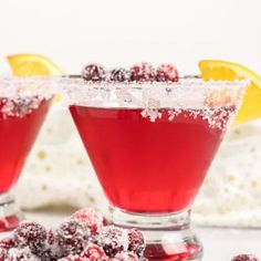 two glasses filled with cranberry martinis and garnished with powdered sugar