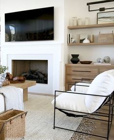 a living room filled with furniture and a flat screen tv mounted on the wall above a fire place