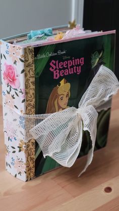 there is a book with a white bow on the front and back cover that says sleeping beauty