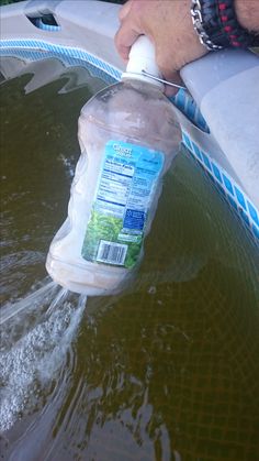 a person is using a bottle to fill up the water