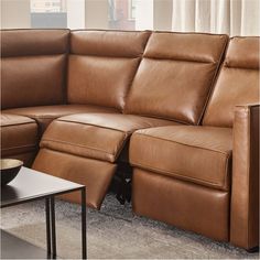 a brown leather sectional sofa with recliners on the bottom and footrests