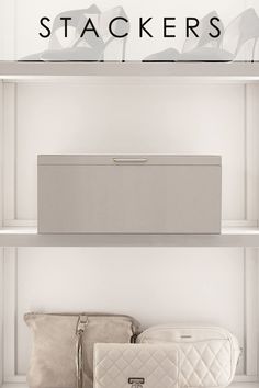 two white purses sitting on top of shelves next to each other